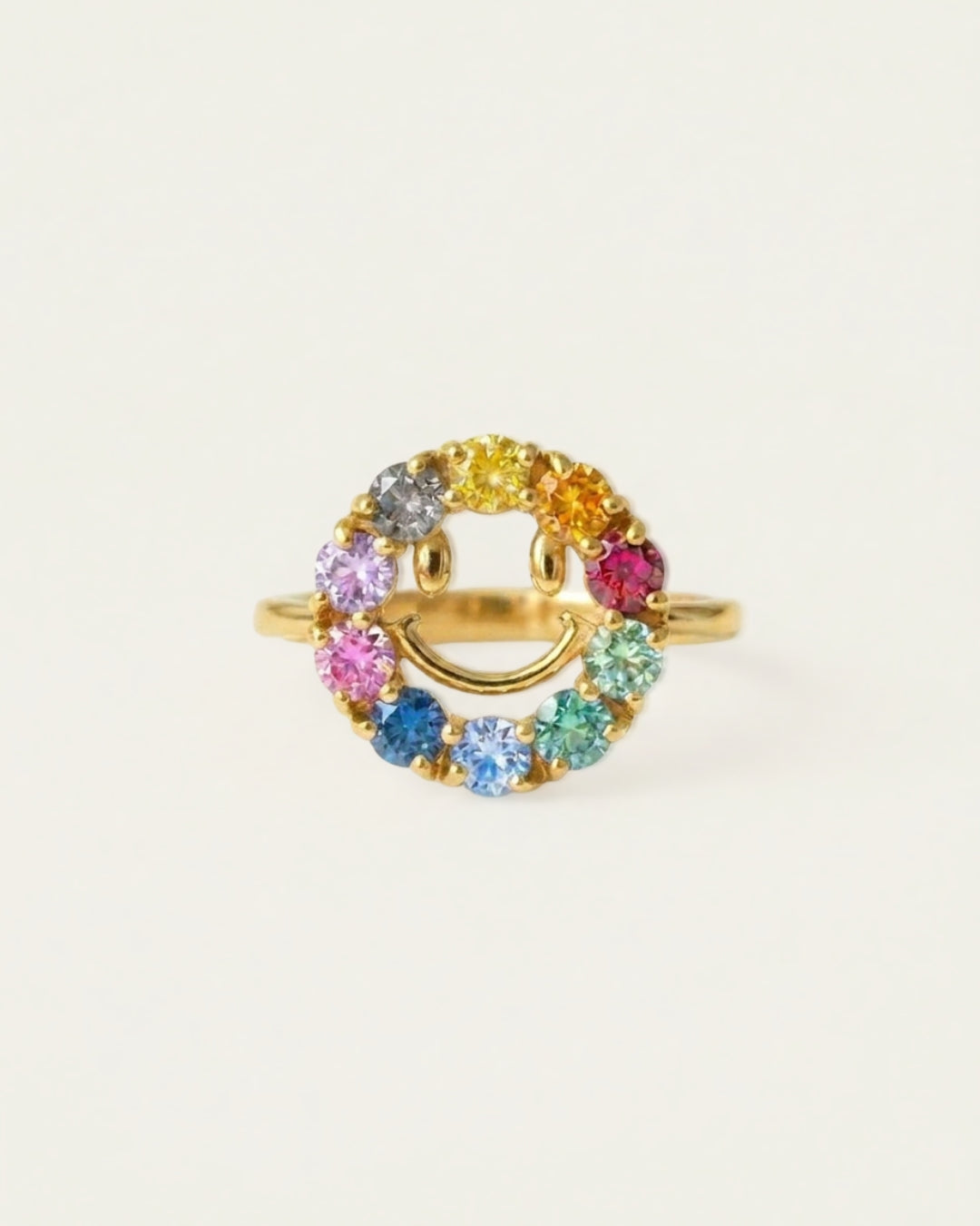 Smiley Ring | Moissanite in yellow gold, resting on a warm linen background
