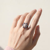 Snowflake Pearl Halo Ring in black gold, worn on a model