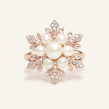 Close-up of the Snowflake Pearl Halo Ring in rose gold, resting on a warm linen background