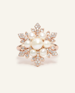 Close-up of the Snowflake Pearl Halo Ring in rose gold, resting on a warm linen background