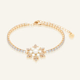 Snowflake Pearl Tennis Bracelet in yellow gold, resting on a warm linen background