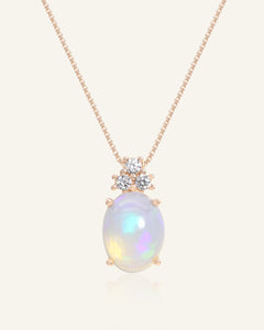Close-up of the Solace Opal Necklace in rose gold, resting on a warm linen background