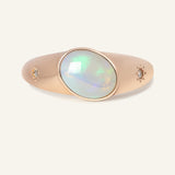 Close-up of the Supernova Signet Opal Ring, resting on a warm linen background