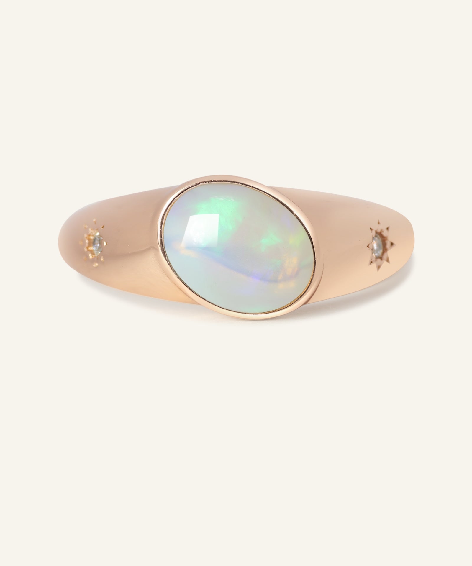 Close-up of the Supernova Signet Opal Ring, resting on a warm linen background
