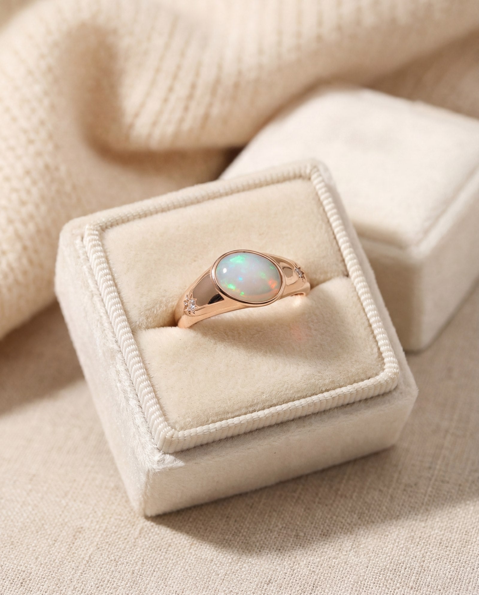 Supernova Signet Opal Ring in rose gold, laid flat on a tabletop