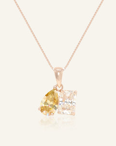 Close-up of the Toi et Moi Necklace (Champagne & White) in rose gold, resting on a warm linen background