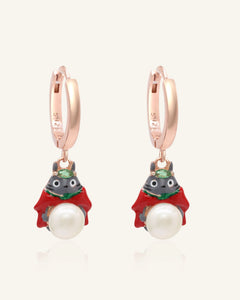 Close-up of the Totoro Huggies | White Freshwater Pearl in rose gold, resting on a warm linen background
