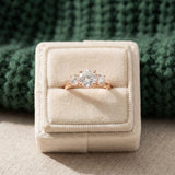 Trilogy Moissanite Ring | Elate in rose gold, laid flat on a tabletop