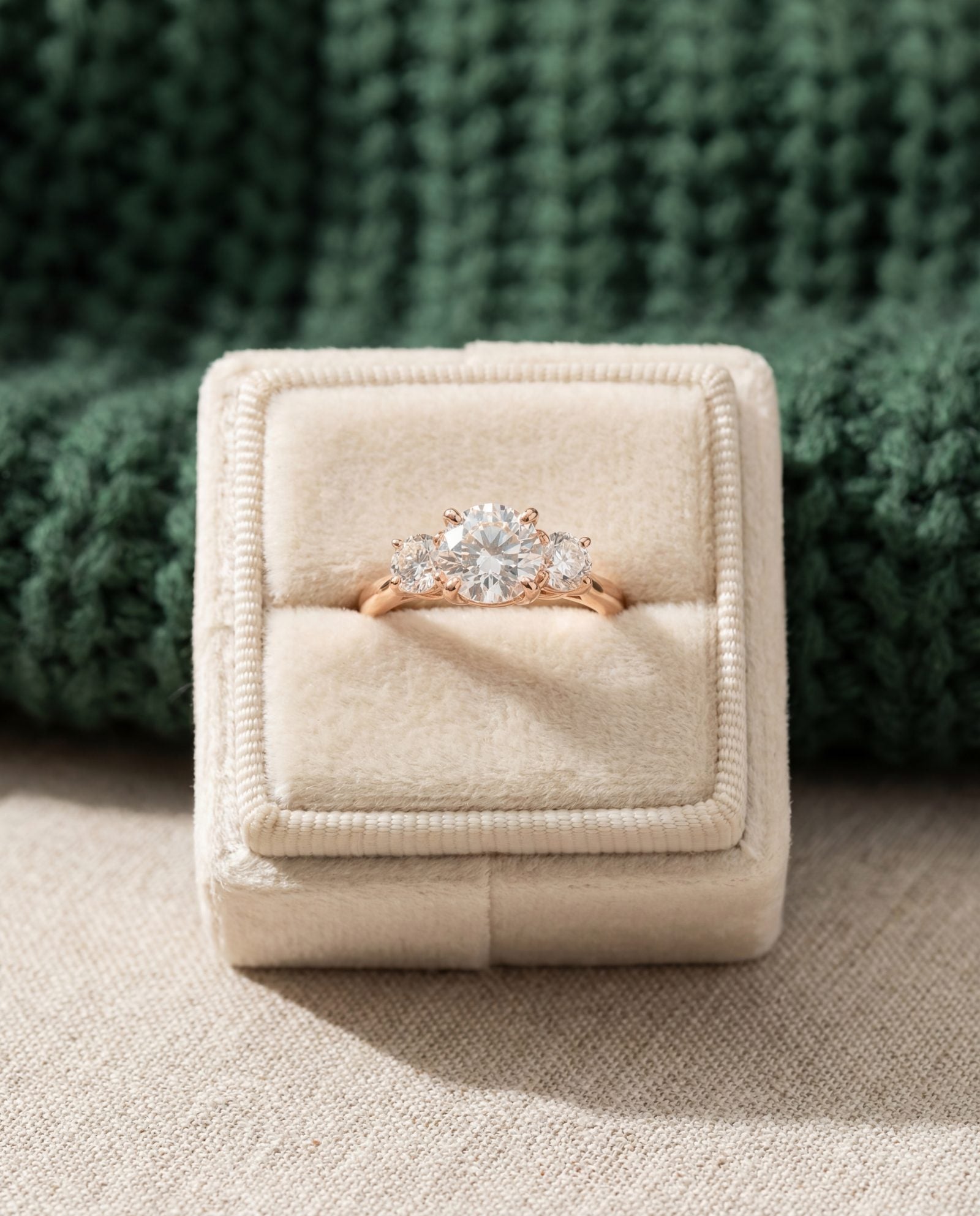 Trilogy Moissanite Ring | Elate in rose gold, laid flat on a tabletop