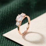 Trilogy Moissanite Ring | Elate in rose gold, laid flat on a tabletop