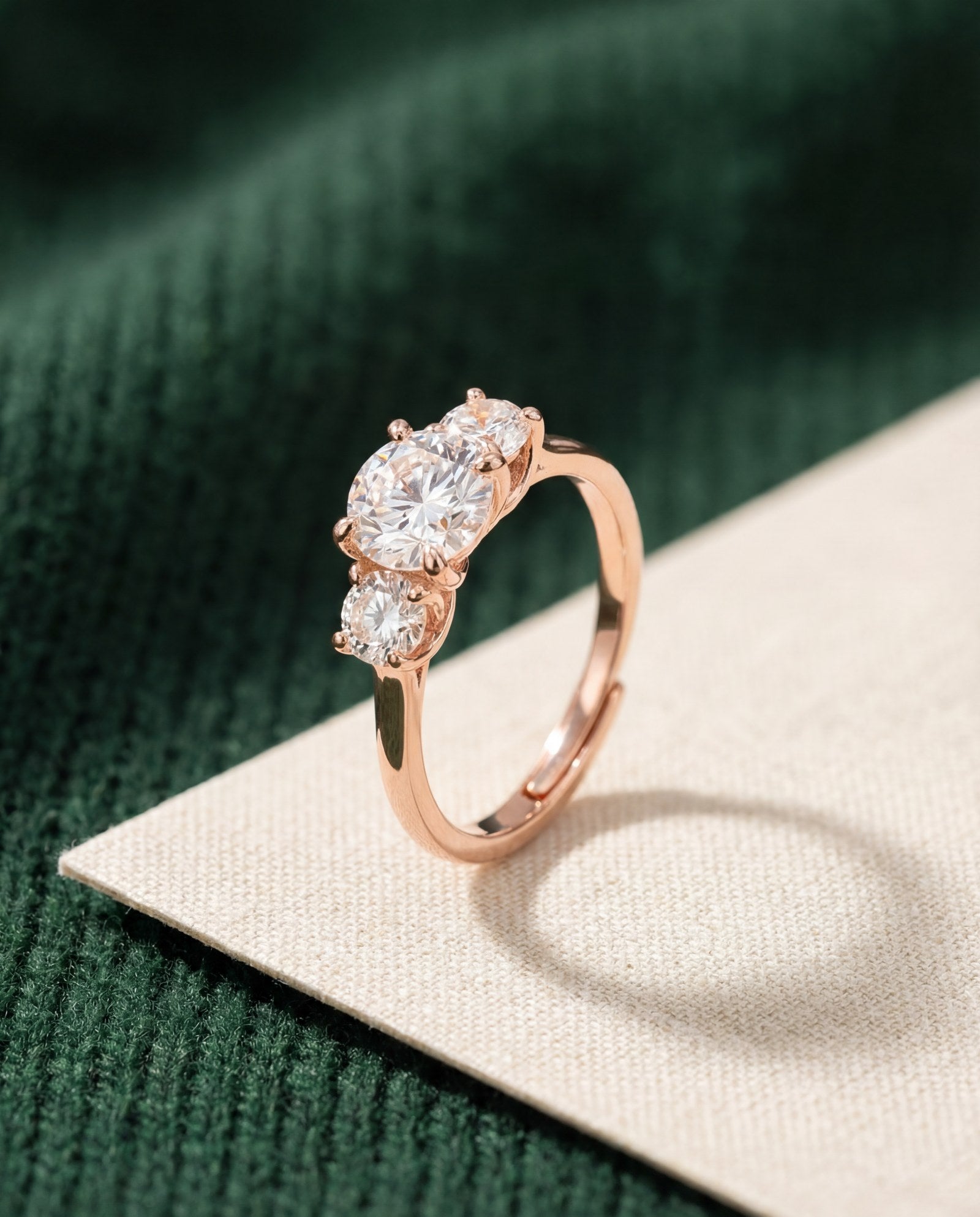 Trilogy Moissanite Ring | Elate in rose gold, laid flat on a tabletop