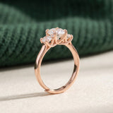 Trilogy Moissanite Ring | Elate in rose gold, laid flat on a tabletop