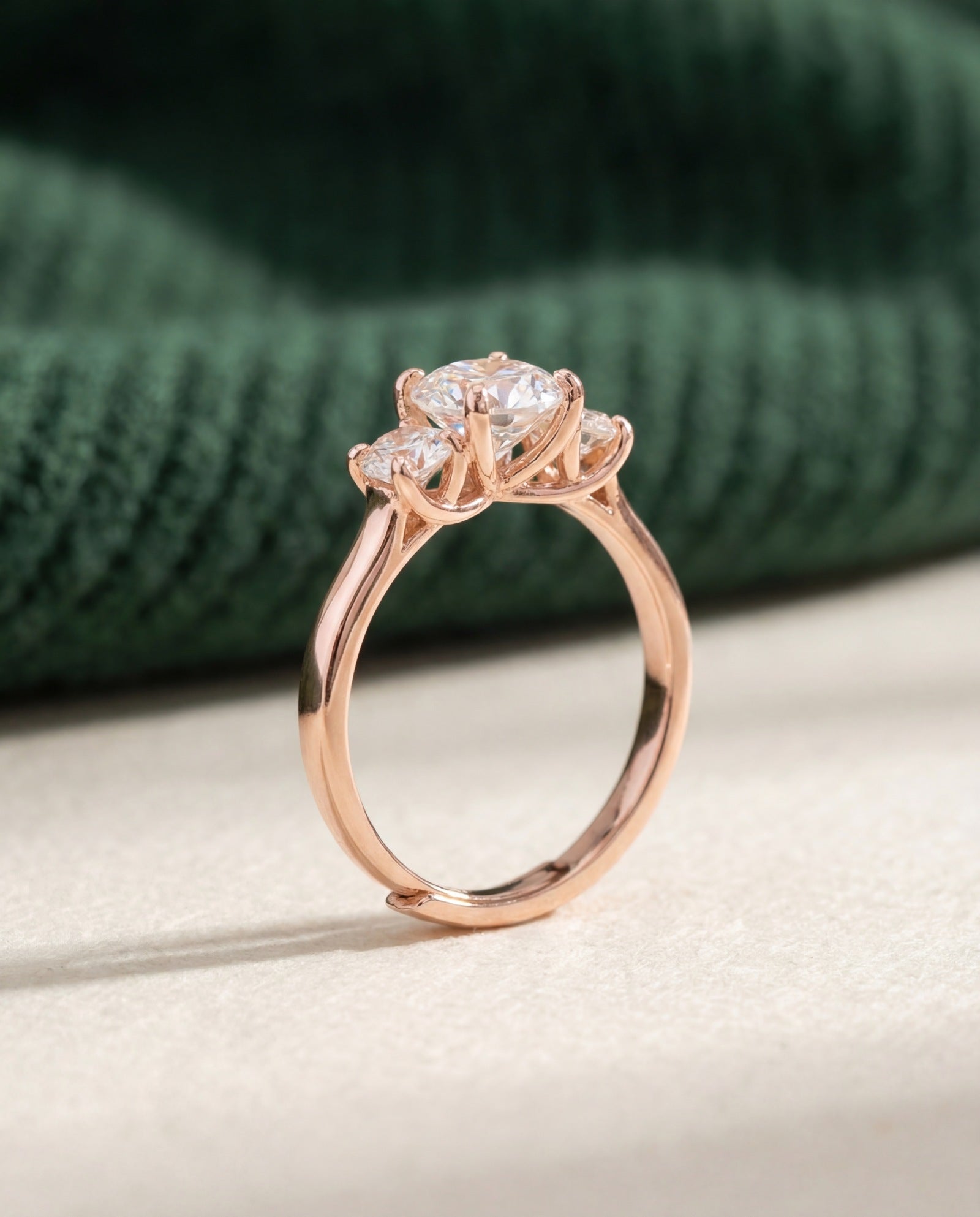 Trilogy Moissanite Ring | Elate in rose gold, laid flat on a tabletop