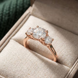 Trilogy Moissanite Ring | Elate in rose gold, laid flat on a tabletop