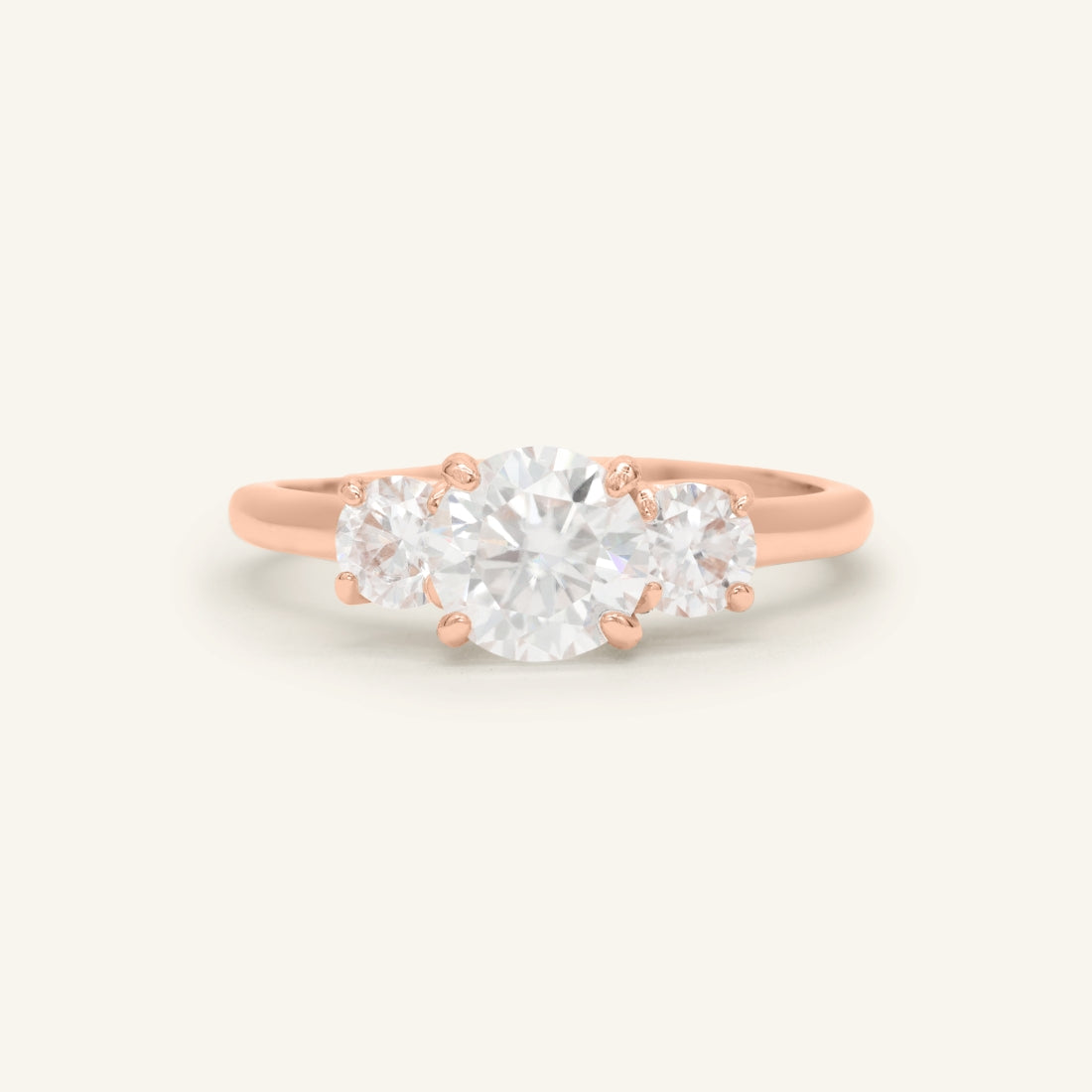 Close-up of the Trilogy Moissanite Ring | Elate in rose gold, resting on a warm linen background