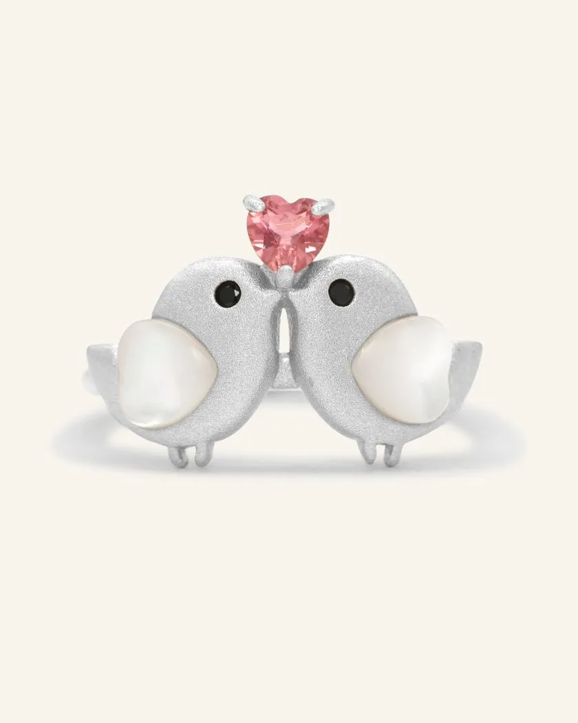 A charming silver ring with two birds, each with mother of pearl hearts, and a pink tourmaline heart set above them.