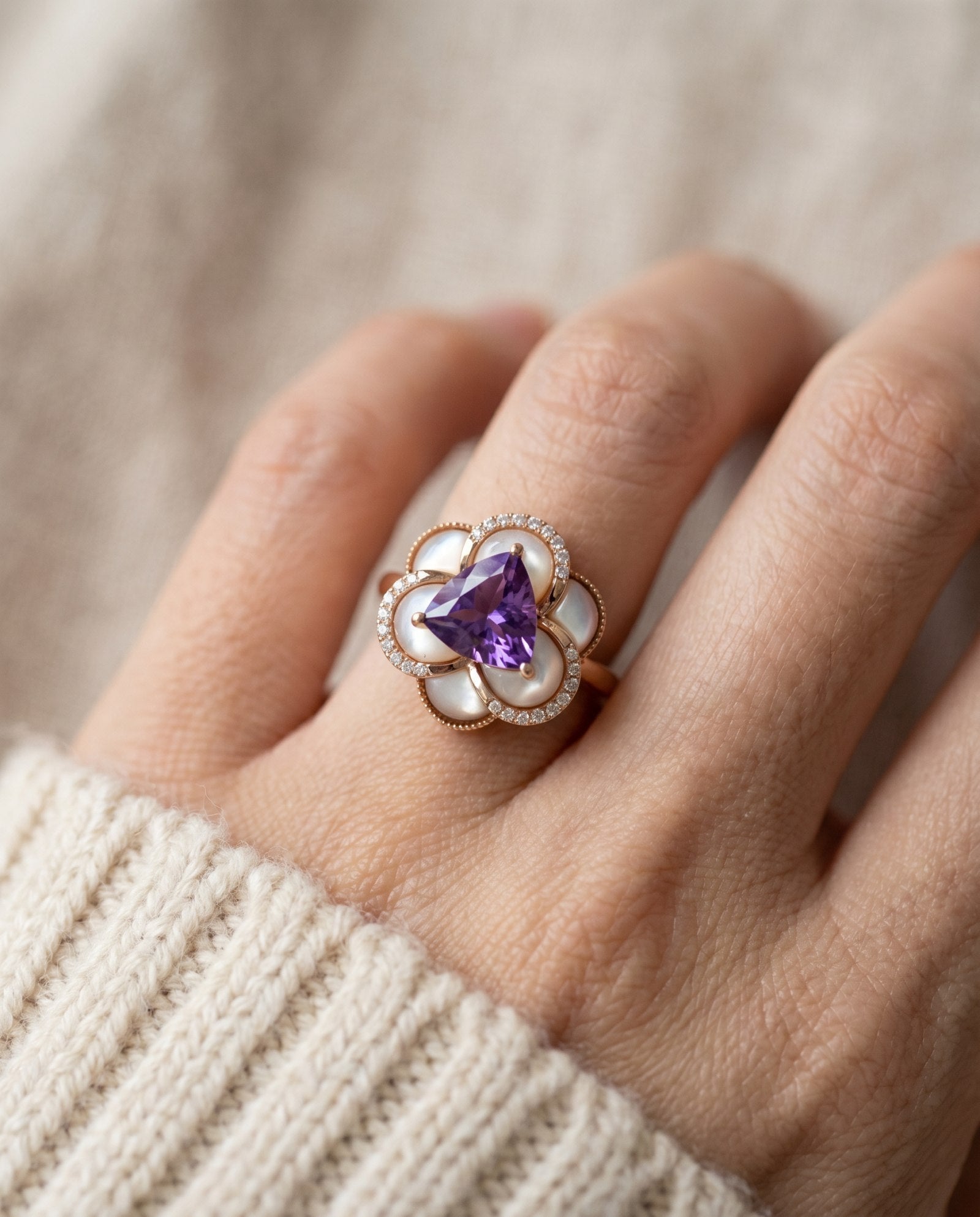 Scale shot of the Violet Grande Bloom Ring in Rose Gold worn on a finger to show the 10.5mm statement floral coverage.