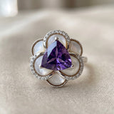 Soft-lit close up of the Violet Grande Bloom Ring in Silver, showcasing the cool tones of rhodium and purple amethyst.