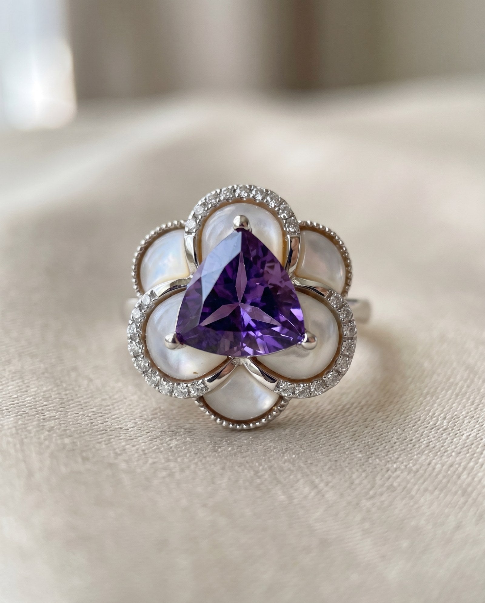 Soft-lit close up of the Violet Grande Bloom Ring in Silver, showcasing the cool tones of rhodium and purple amethyst.