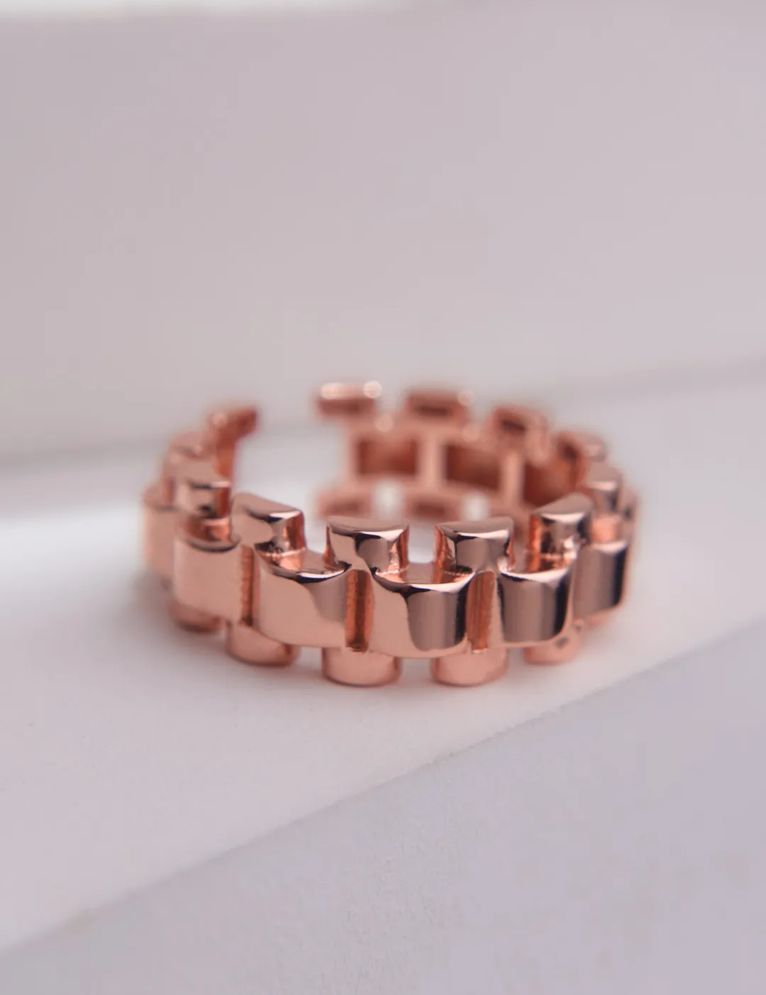 Watch chain link ring in rose gold taken in a style shot.