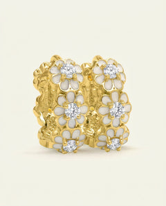 White Daisy Huggies | Moissanite in yellow gold, resting on a warm linen background