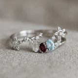 Close-up of the Wildflower Nest stacking duo showing the starry path band cradling the pink and blue gemstone arc.