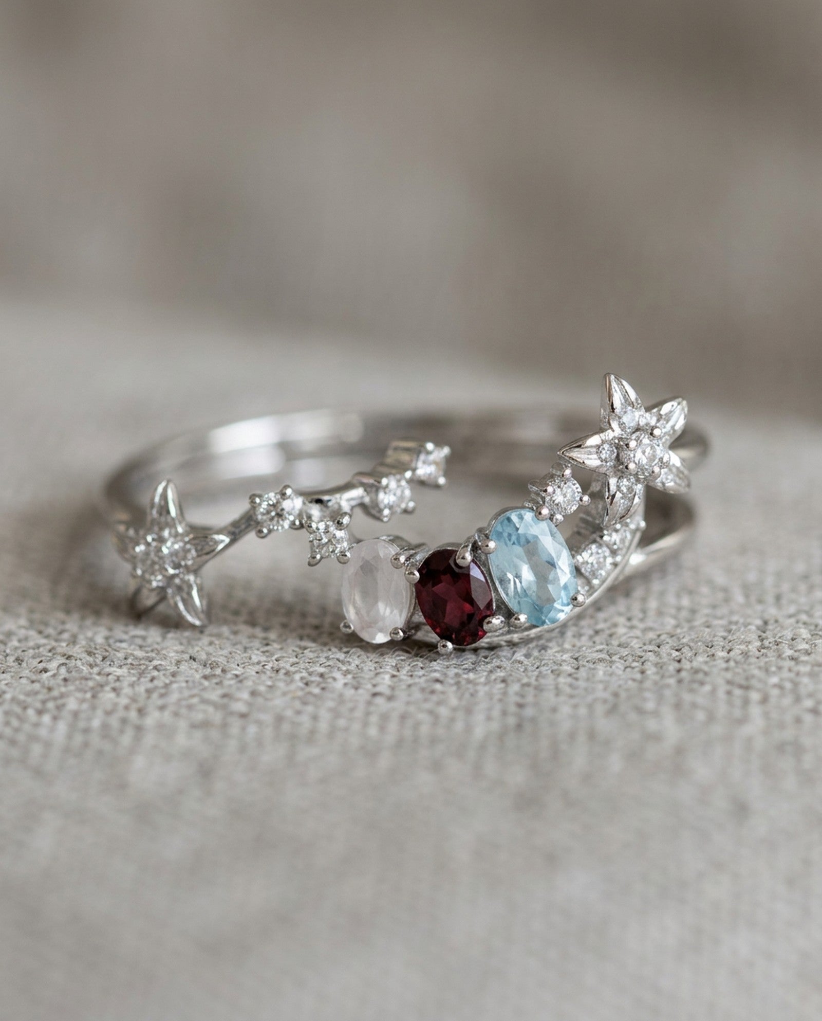 Close-up of the Wildflower Nest stacking duo showing the starry path band cradling the pink and blue gemstone arc.