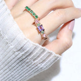 Arc de Triomphe Amethyst Ring in rose gold, close-up worn beside a green gemstone band with an ivory sleeve