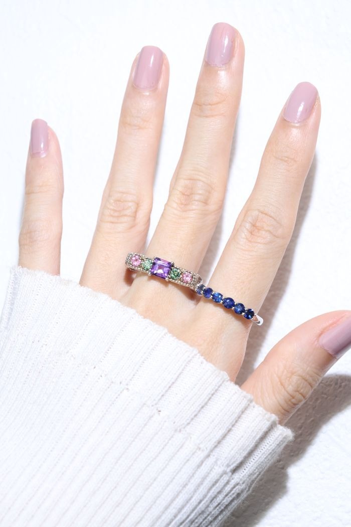 Arc de Triomphe Amethyst Ring in silver, worn on an open hand beside a blue gemstone band