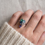 Silver blue topaz clover ring with dangling violet iolite worn on a hand
