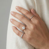 Braided Bliss Band in silver, worn on a hand against white fabric