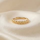 Braided Bliss Band in yellow gold, braided band displayed on folded cream fabric