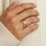 Braided Bliss Band in yellow gold, worn in a ring stack with an ivory knit sleeve