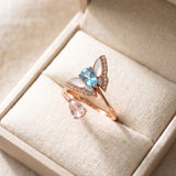 Rose gold butterfly ring with Swiss blue topaz, rose quartz and mother-of-pearl wings in an ivory jewellery box