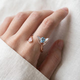 Rose gold butterfly ring with Swiss blue topaz and rose quartz worn on a hand