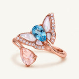 Rose gold butterfly toi et moi ring with pear-cut Swiss blue topaz and rose quartz, mother-of-pearl wings and CZ accents