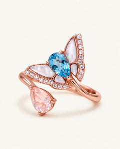 Rose gold butterfly toi et moi ring with pear-cut Swiss blue topaz and rose quartz, mother-of-pearl wings and CZ accents