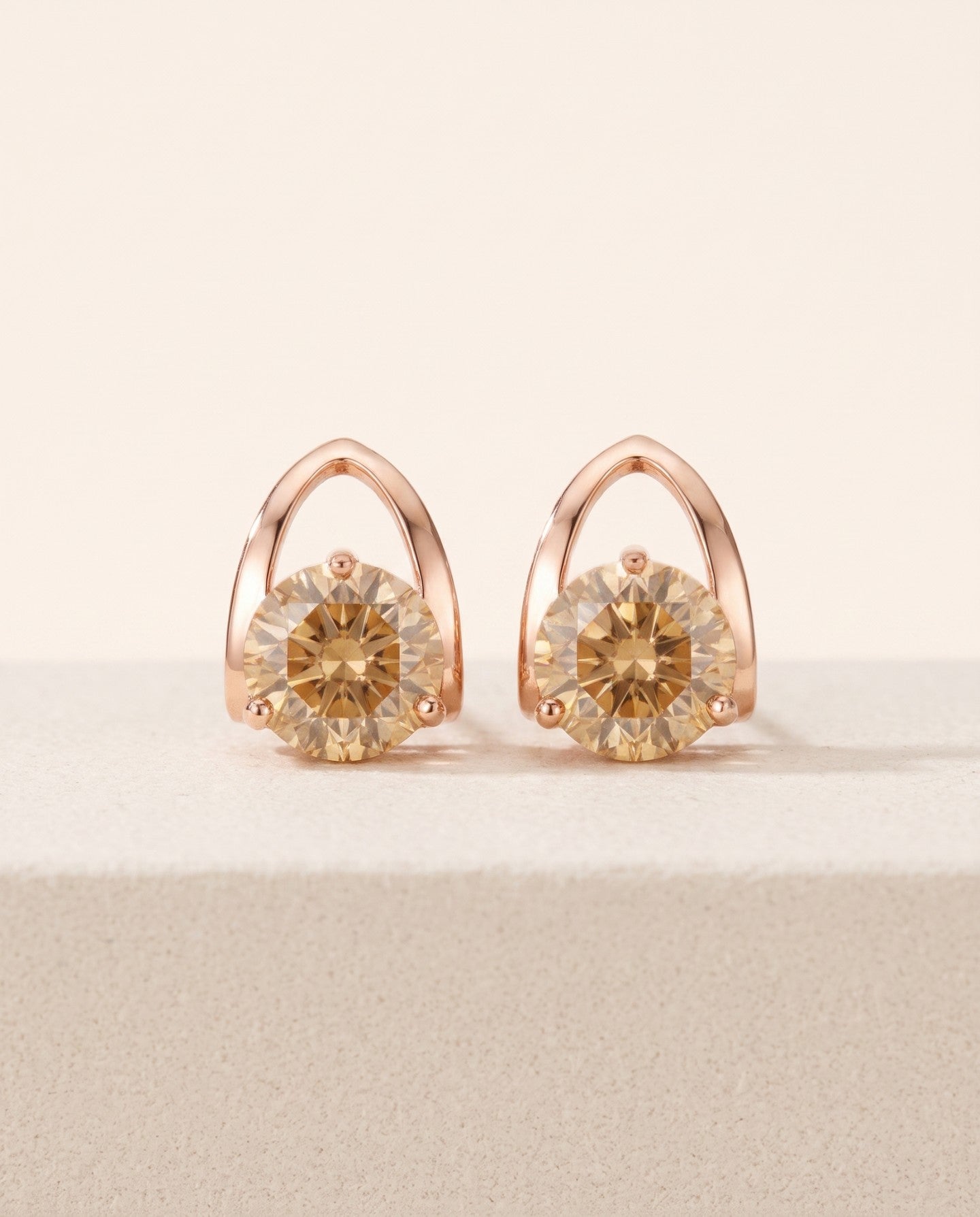 Champagne moissanite stud earrings in rose gold showing the open pointed setting