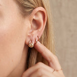 Champagne moissanite stud earrings in rose gold worn on an ear