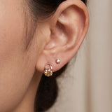Champagne moissanite stud earrings in rose gold worn on an ear