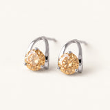 Champagne moissanite stud earrings in silver on an ivory background