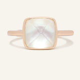 Clear Quartz and Mother of Pearl Sugarloaf Ring in rose gold, front view of the sugarloaf bezel setting on warm ivory
