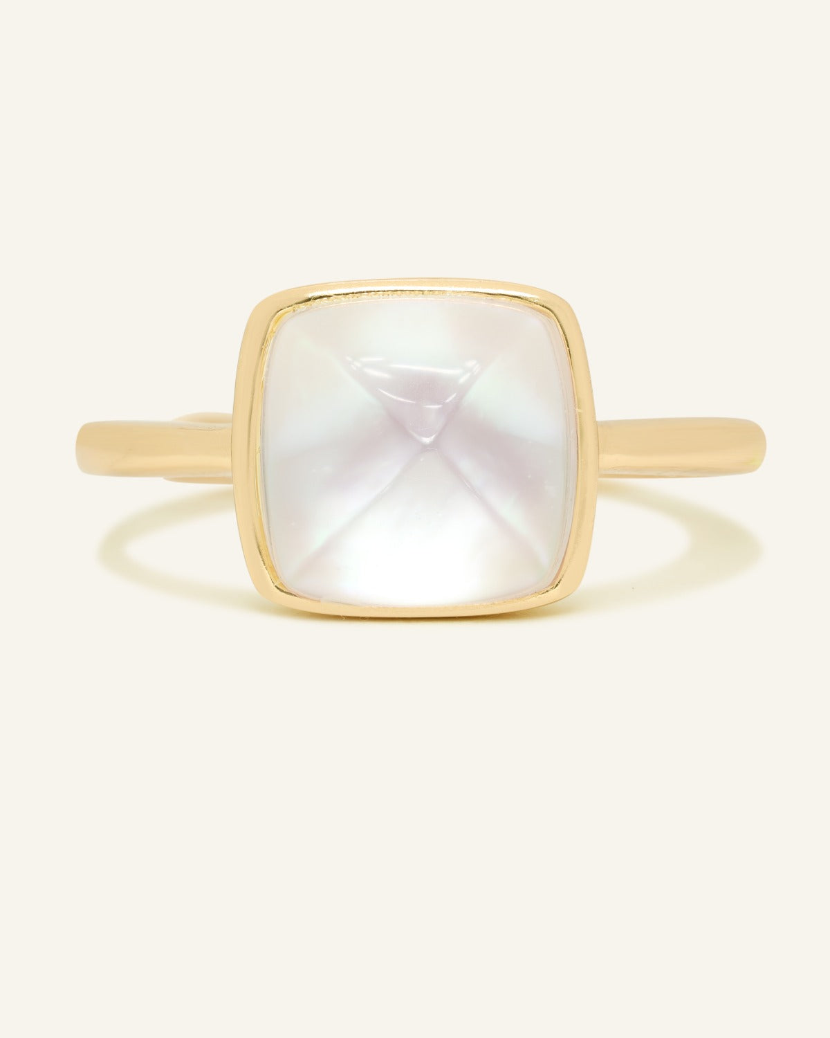 Clear Quartz and Mother of Pearl Sugarloaf Ring in yellow gold, front view of the sugarloaf bezel setting on warm ivory
