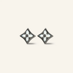 Close-up of a pair of black gold clover monogram studs