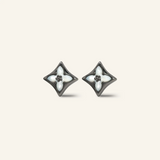 Close-up of a pair of black gold clover monogram studs