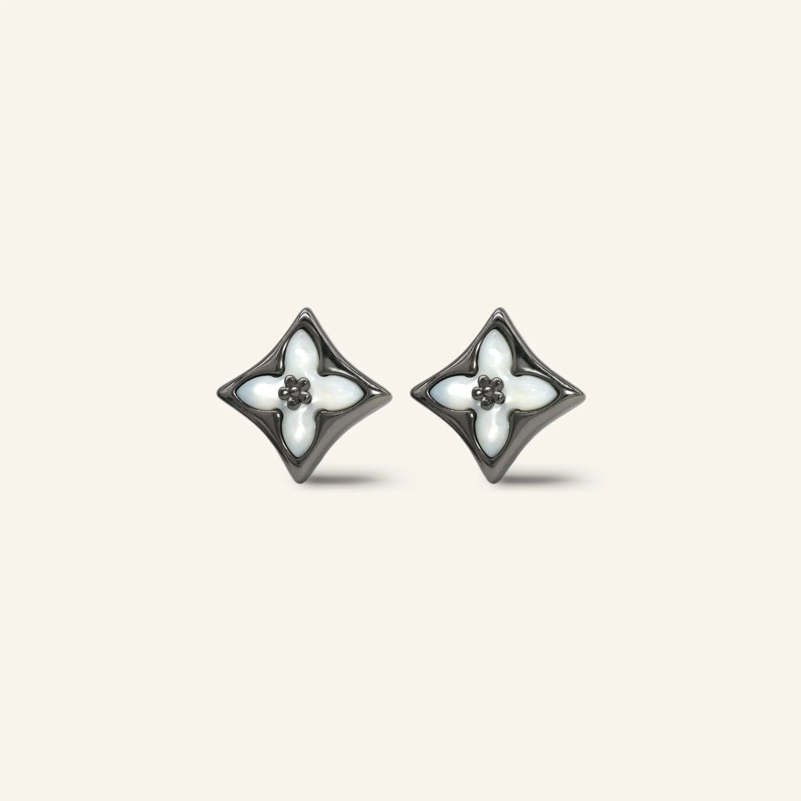 Close-up of a pair of black gold clover monogram studs