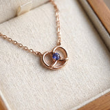 Croissant Heart Tanzanite Necklace in rose gold, resting in a cream jewellery box
