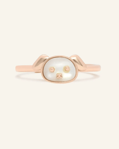 Close-up of the Dog Zodiac Ring in Mother of Pearl, resting on a warm linen background