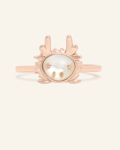 Close-up of the Dragon Zodiac Ring in Mother of Pearl, resting on a warm linen background