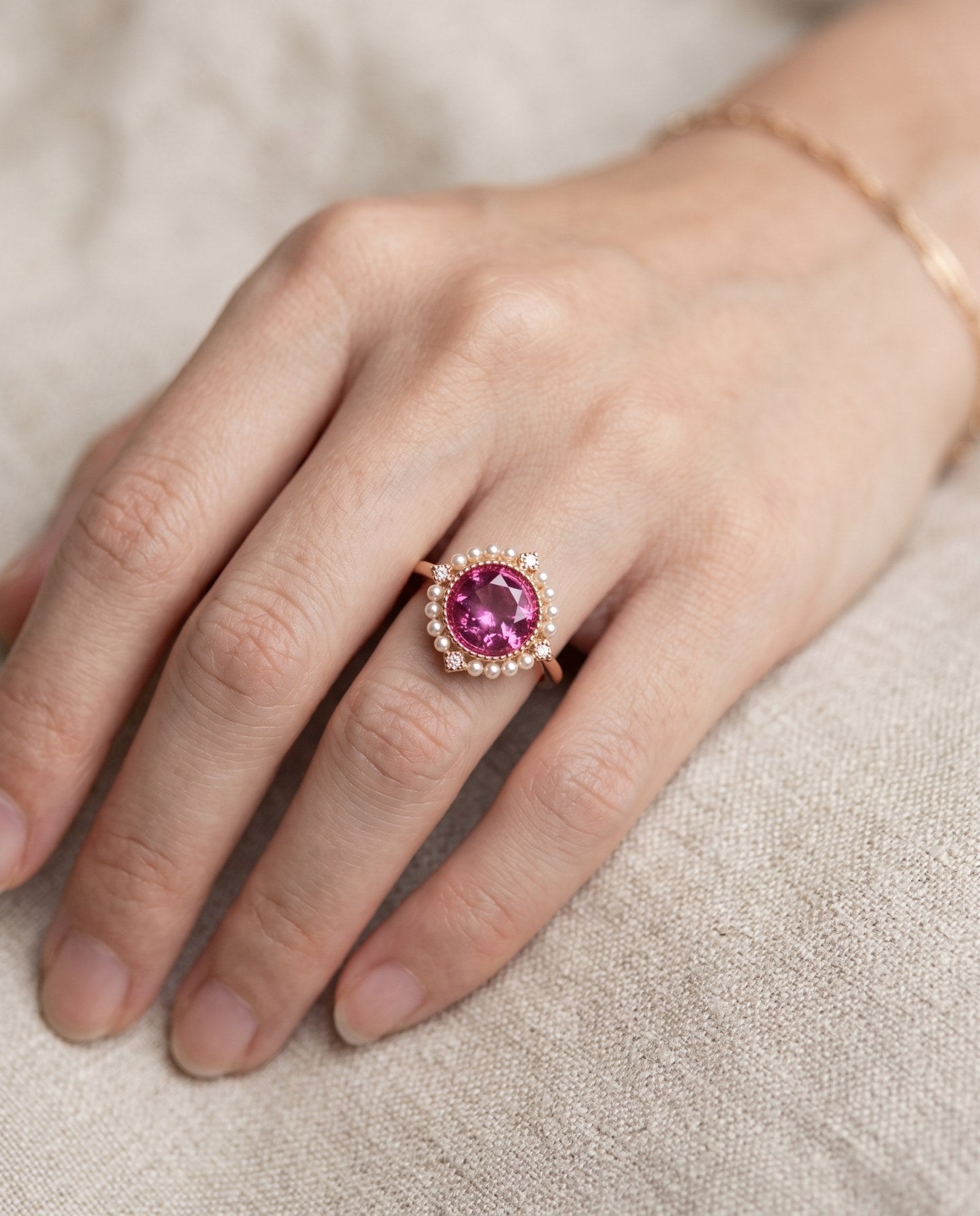 Duchess Pink Topaz Ring in rose gold worn on hand against neutral linen